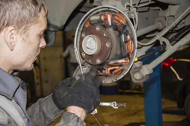 мастер меняет тормозной суппорт